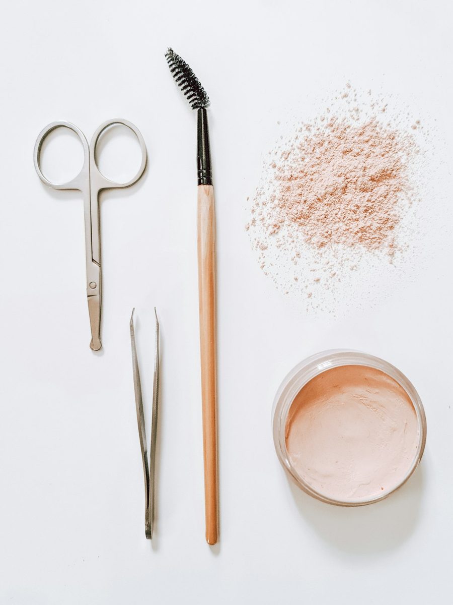 White powder on clear glass jar beside silver scissors