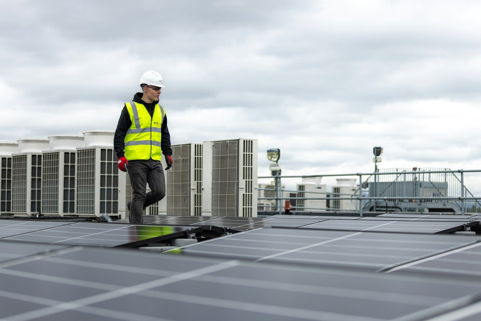 Technician walking past rooftop HVAC units
