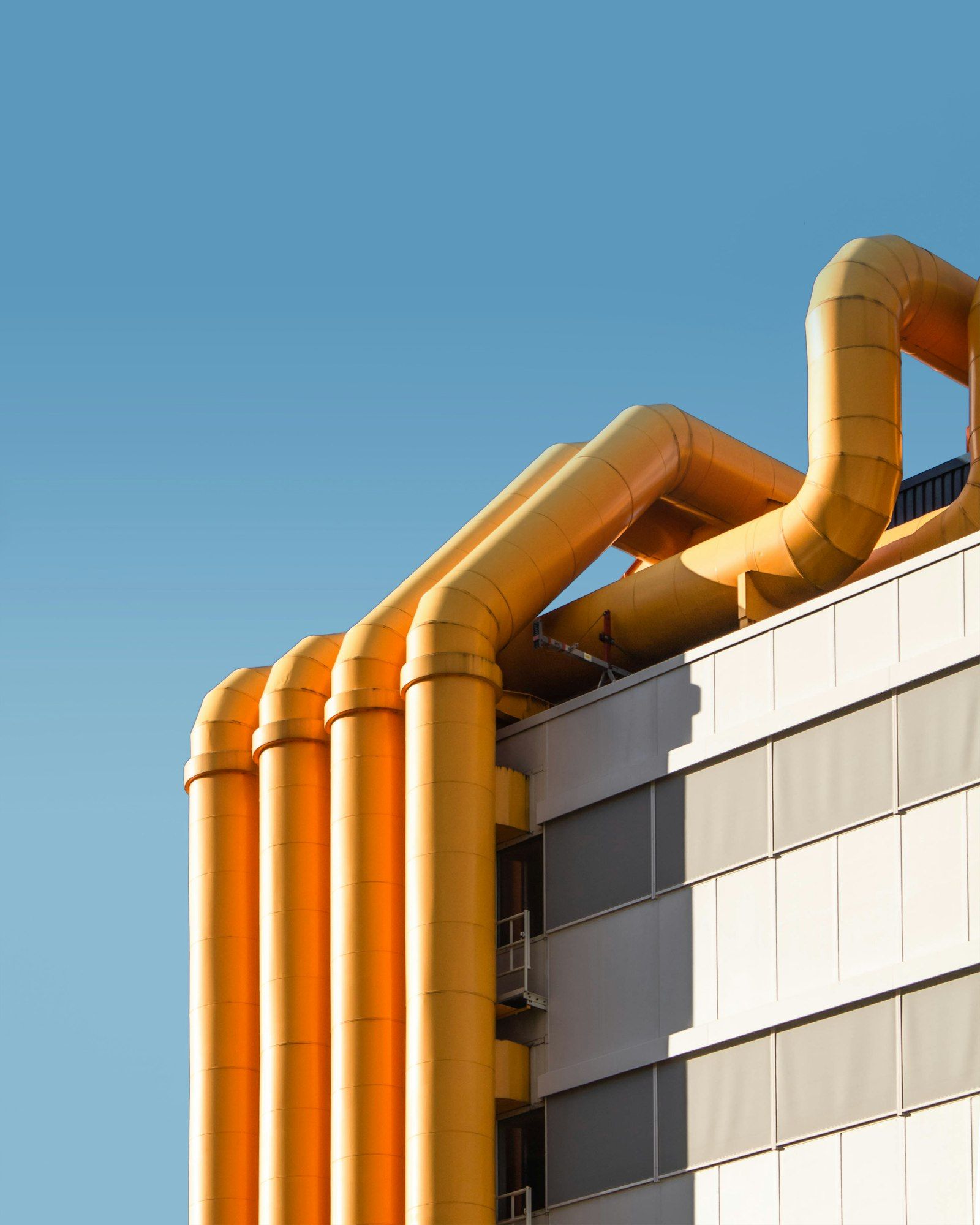 Orange ductwork on a building against blue sky