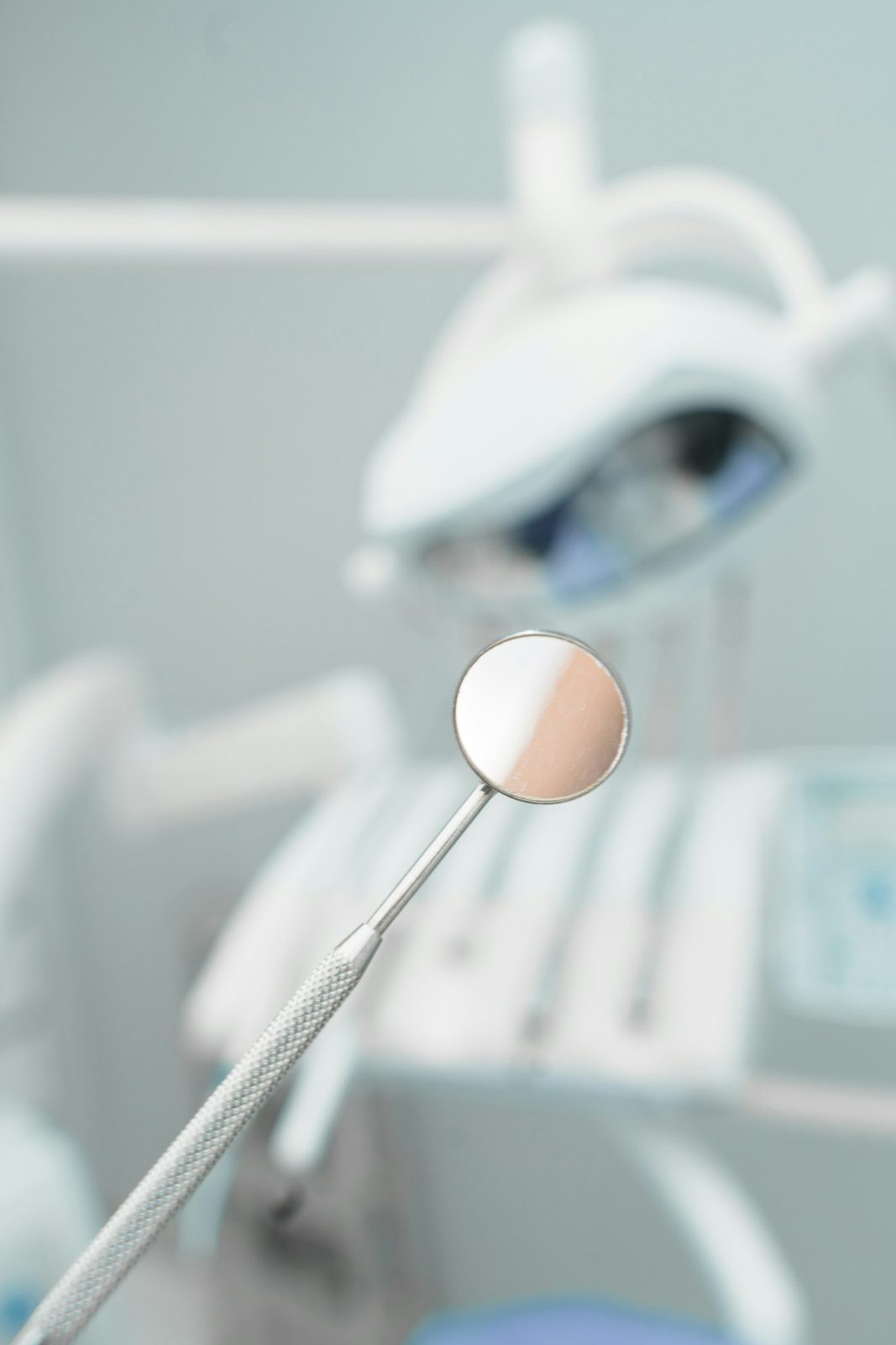 A dental mirror in front of a modern treatment chair