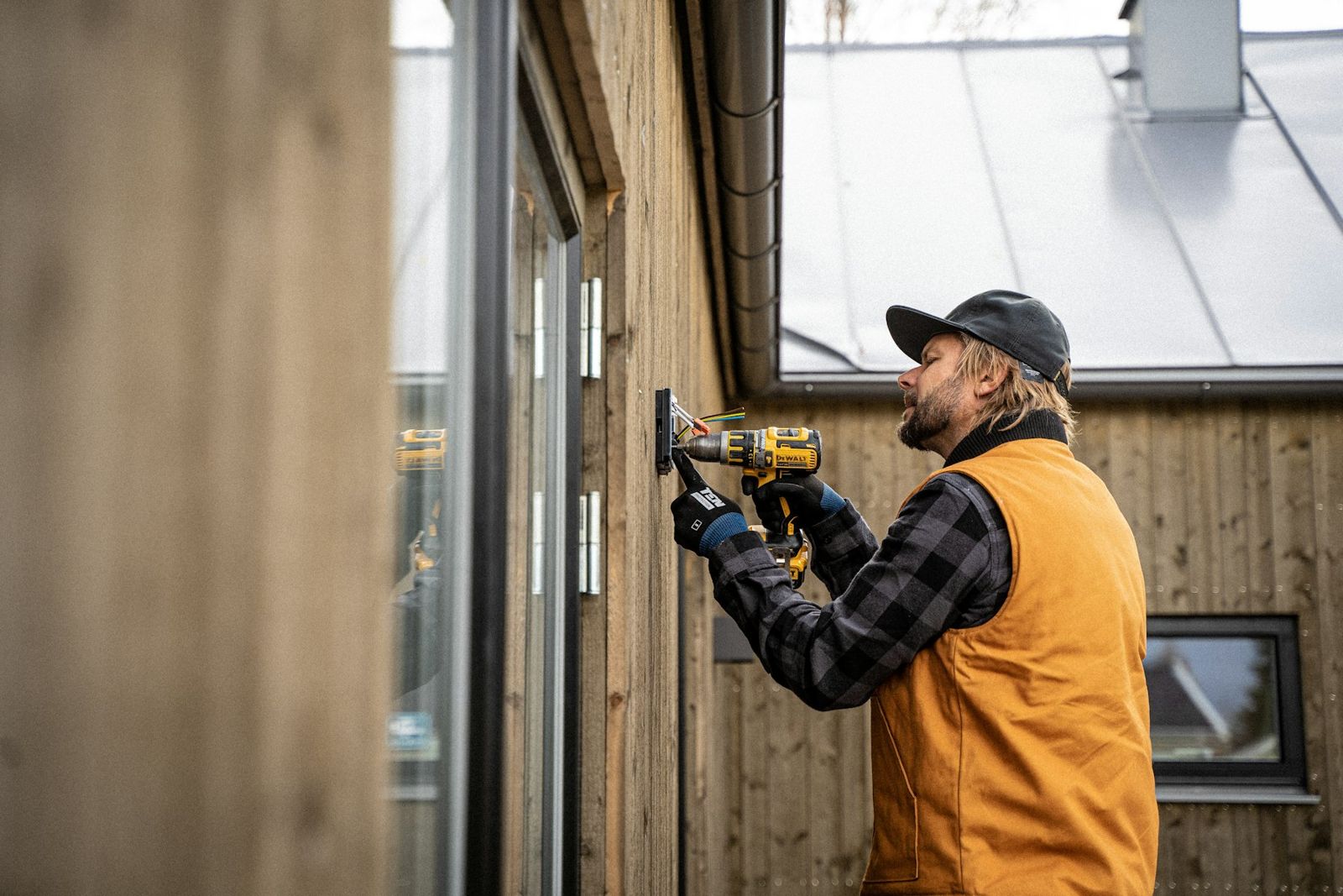 Electrician installing a fixture on a home exterior