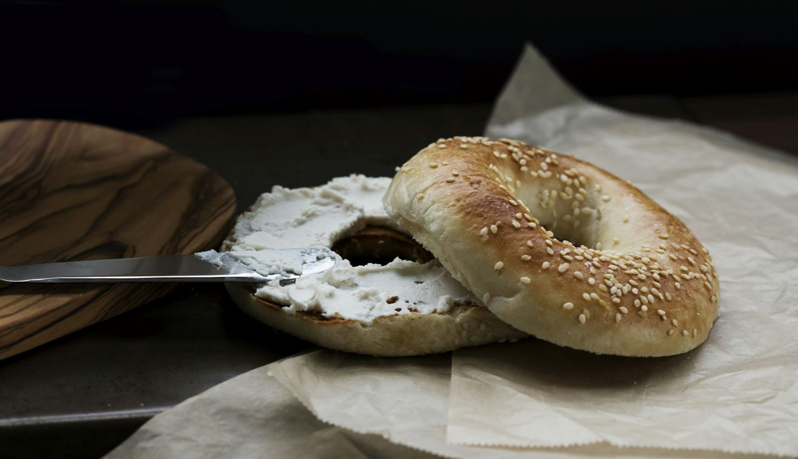 A sesame bagel spread thick with cream cheese