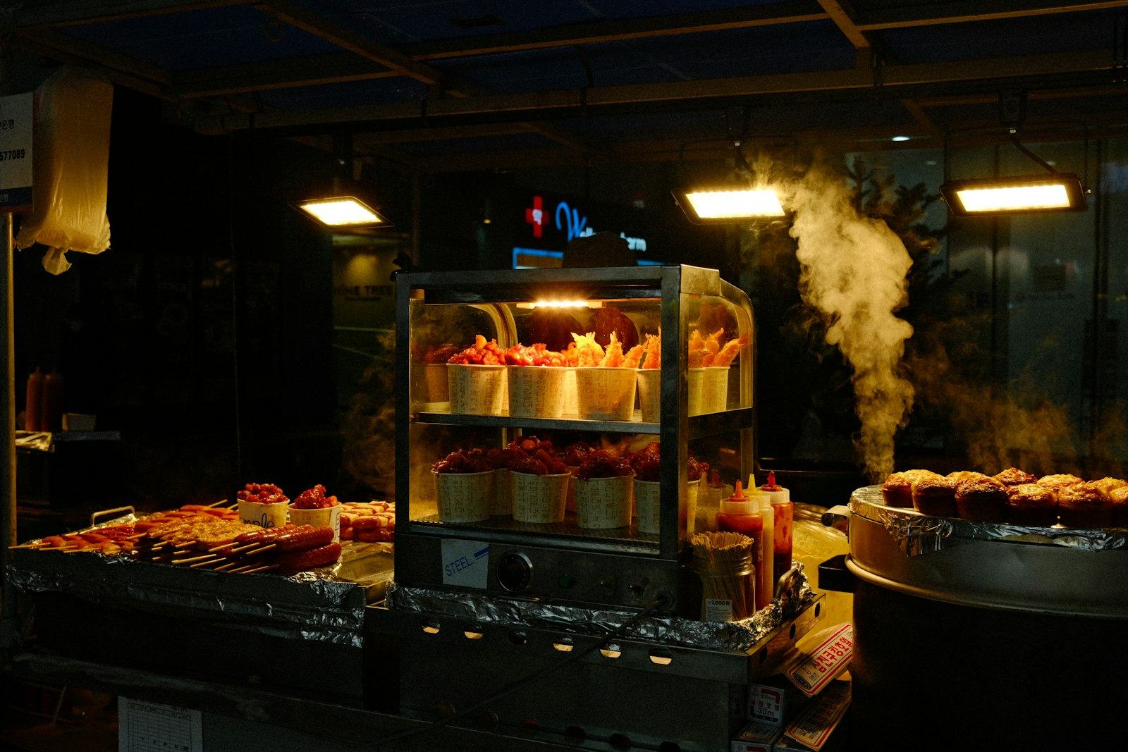 Steam rising from a street kitchen at night