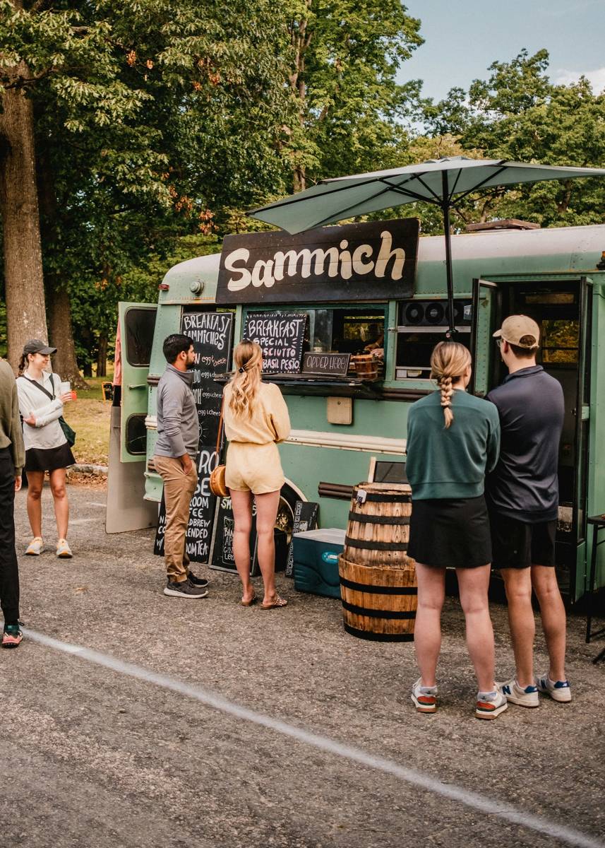 Crowd lined up at a food truck outdoors