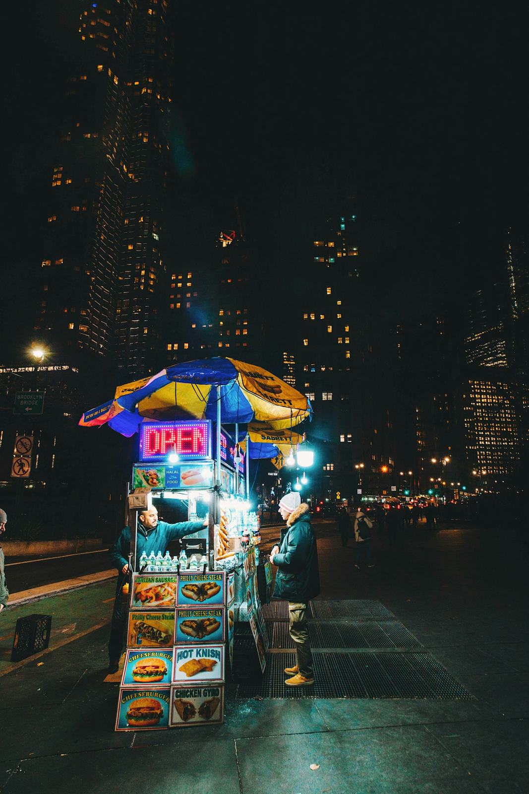 Food cart glowing on a city street at night