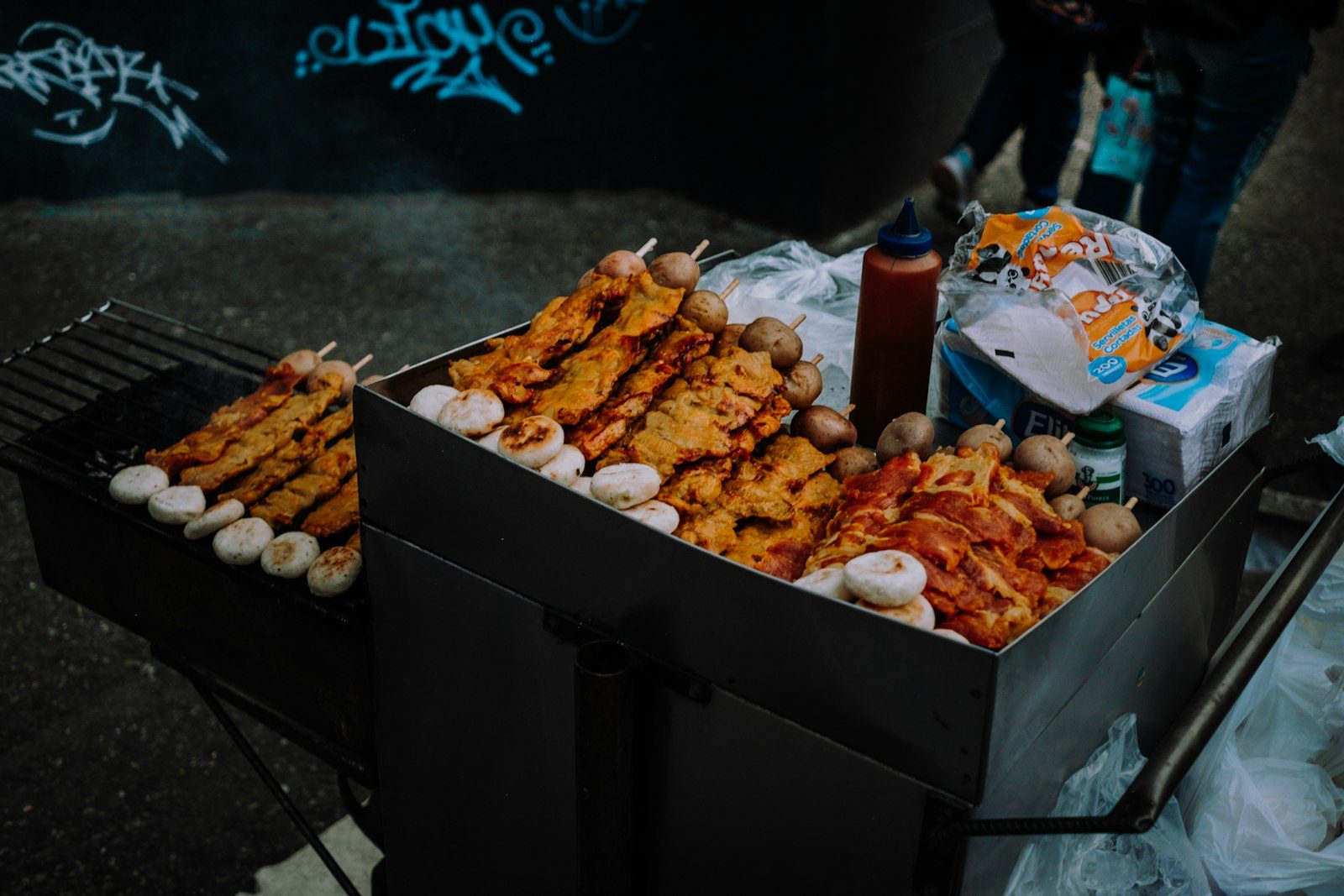 Grilled skewers on a street grill at night