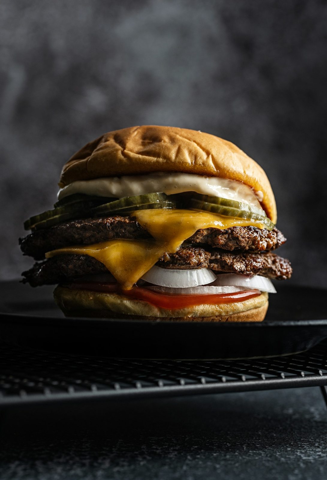 Double smash burger with melted cheese on a grill