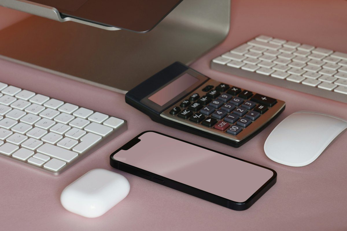A desk with a keyboard, mouse, and cell phone