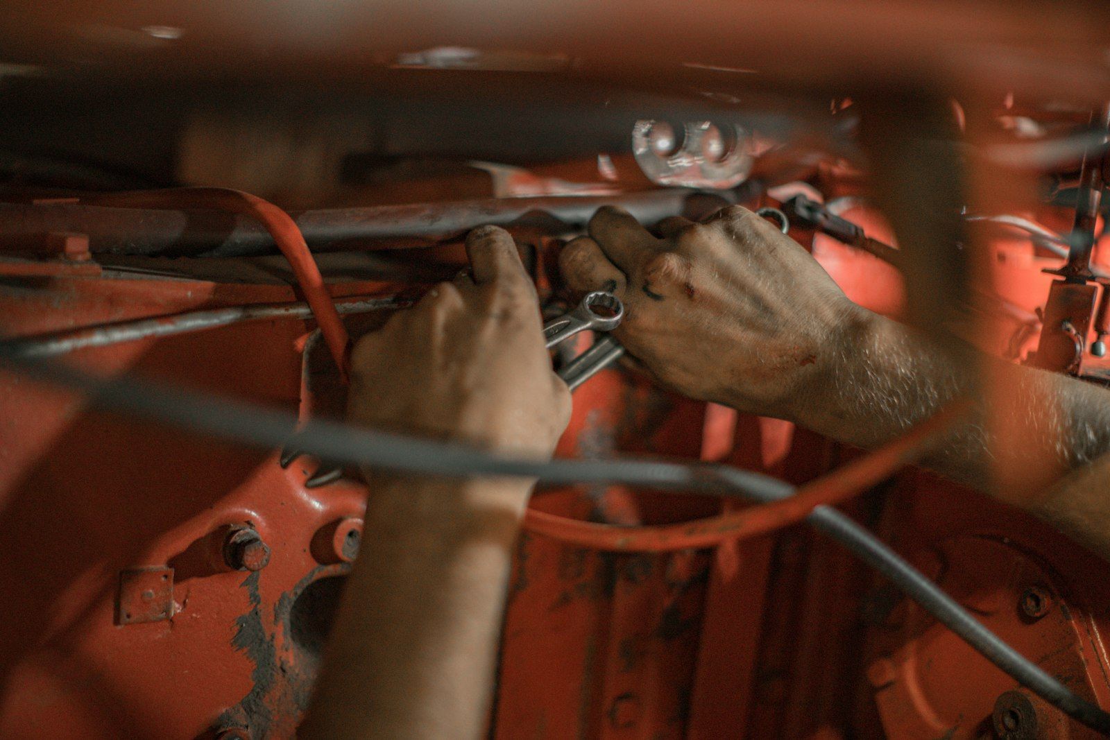 Hands working on wiring under a dash