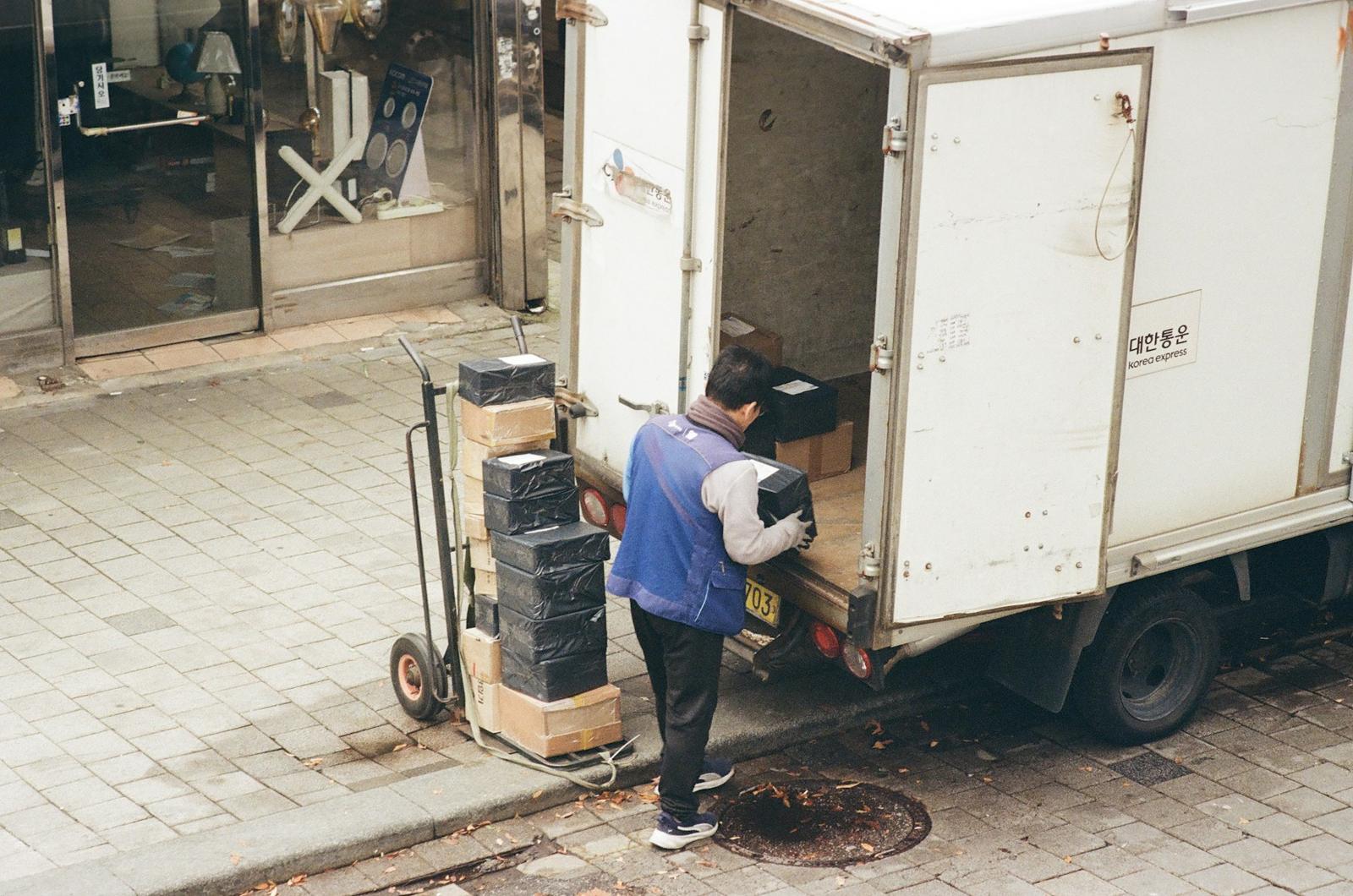 Crew member moving boxes with a dolly