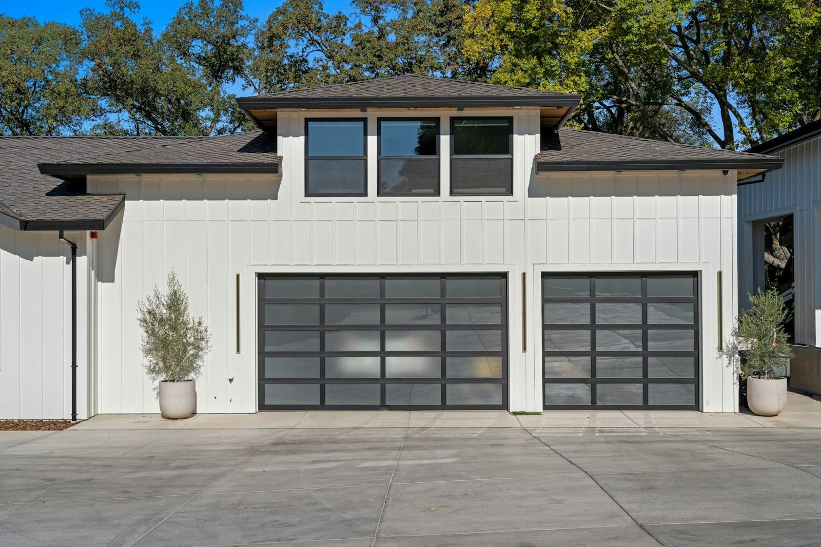 Modern white home with black glass garage doors