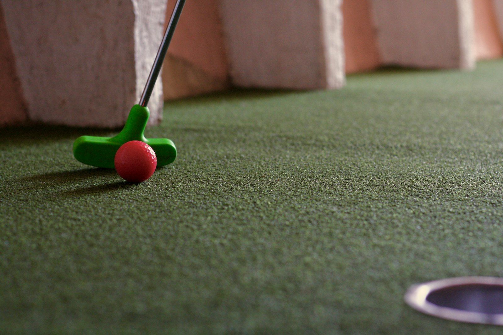 Putter and red ball on a green