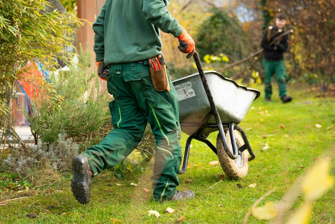 A Fieldstone crew member moving a wheelbarrow across a lawn
