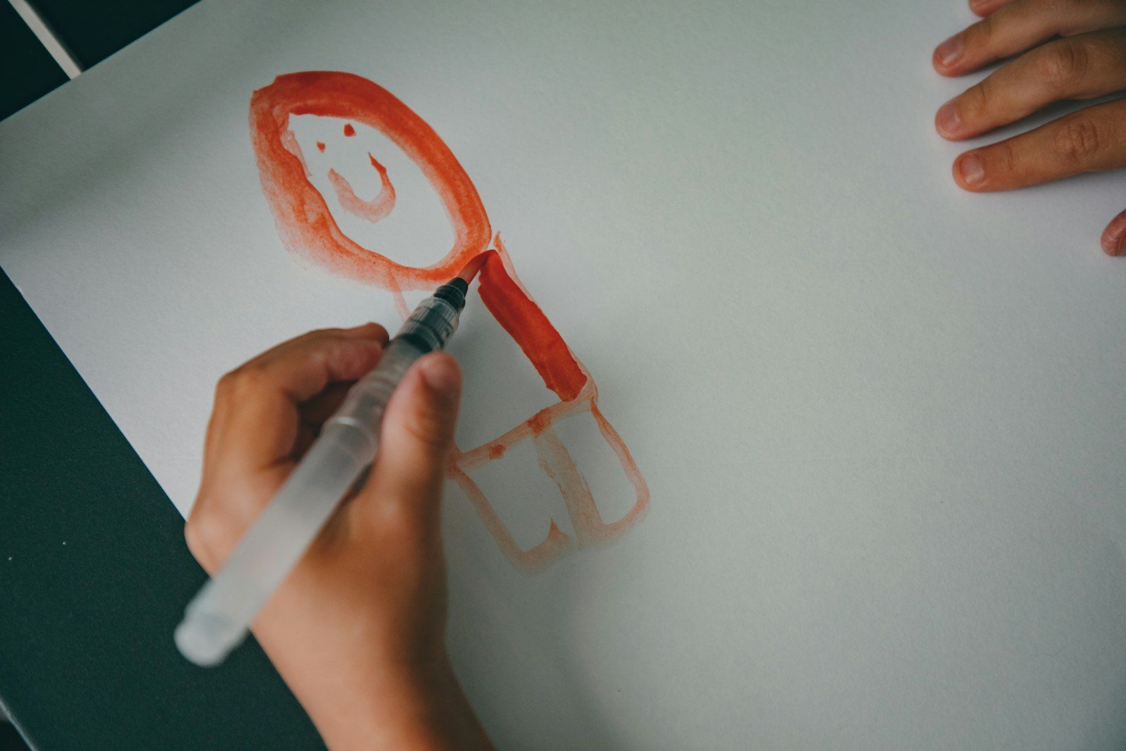 Child drawing a face with a marker