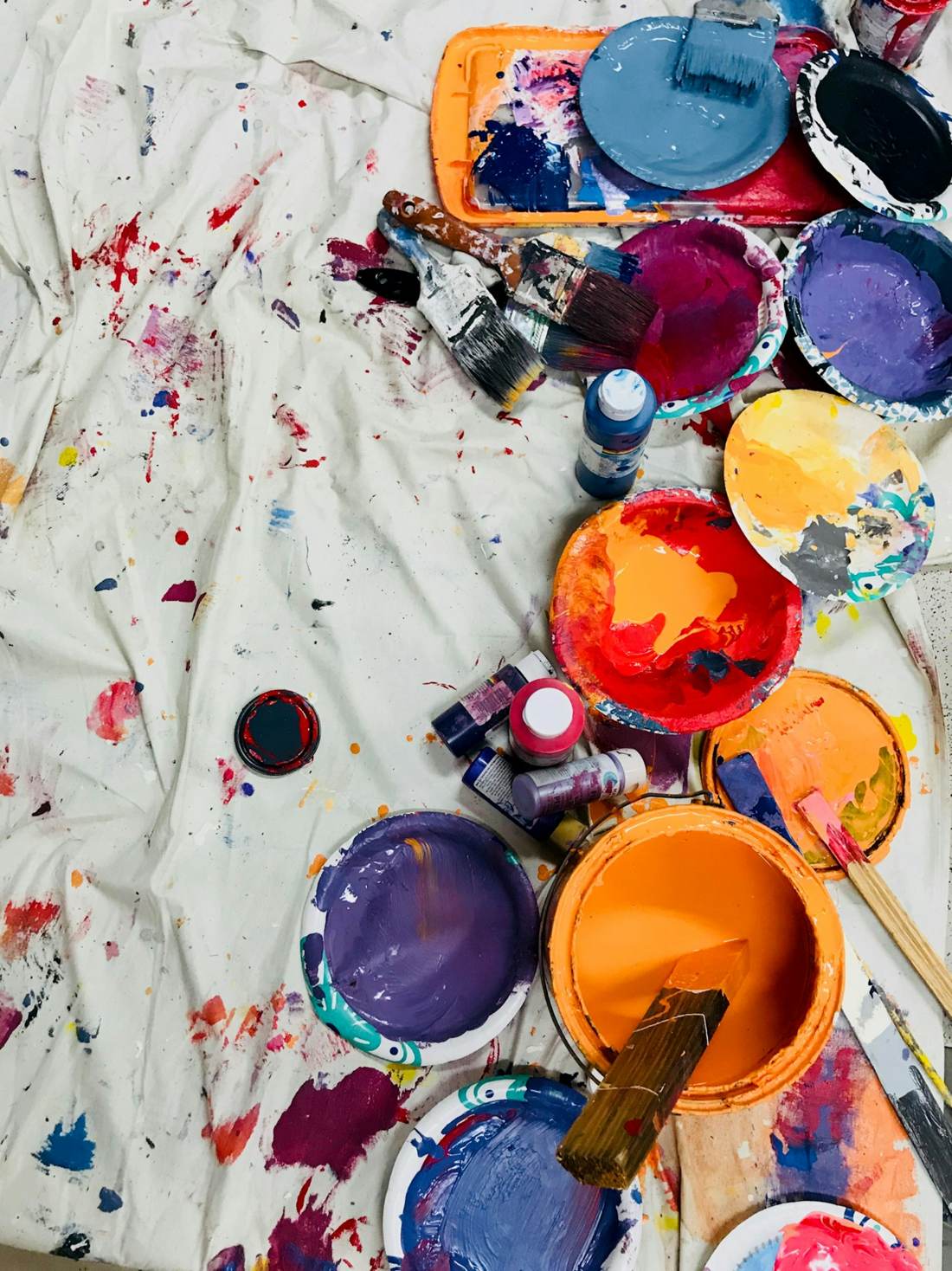 Paint pots and brushes on a messy table