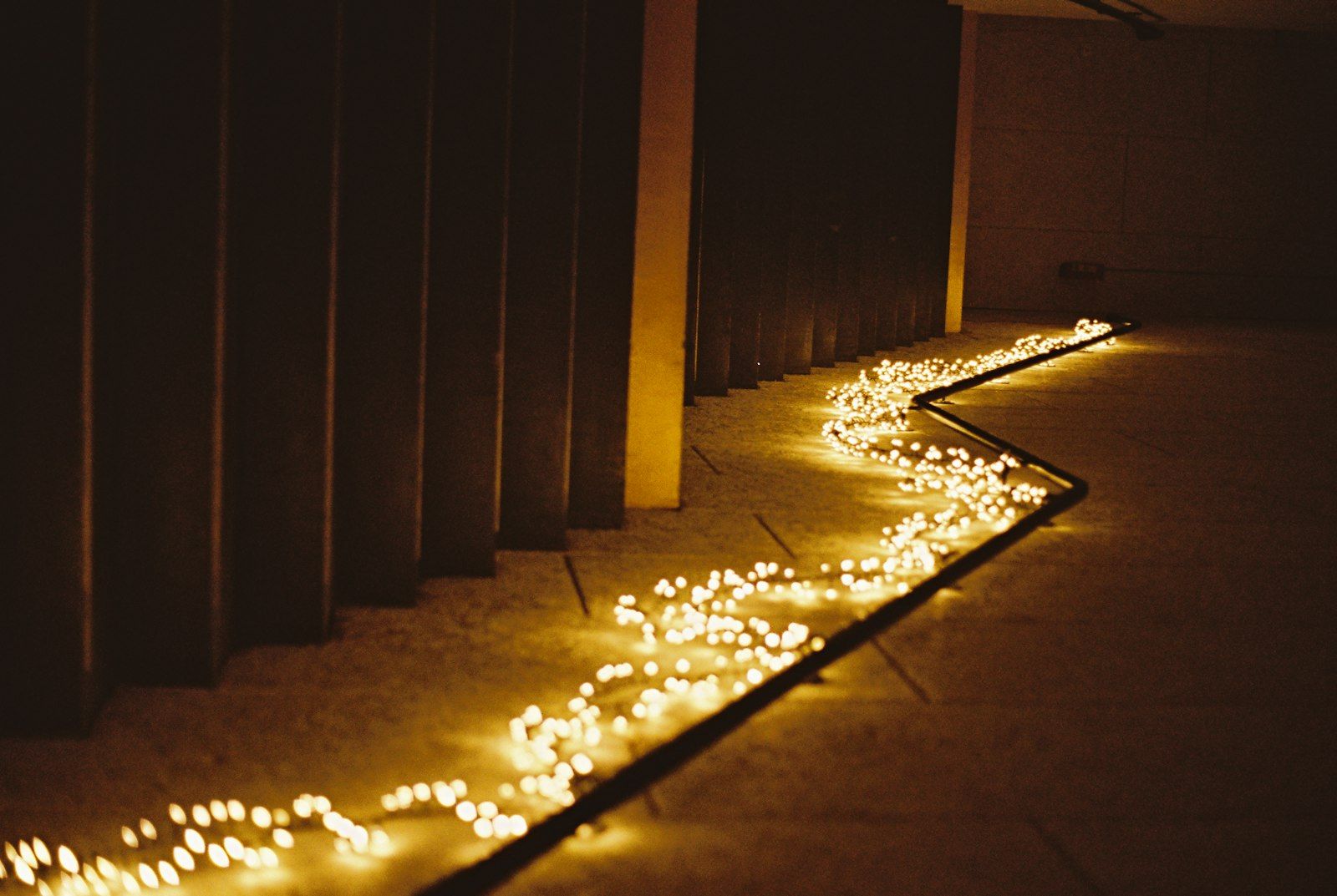 A walkway lined with warm lights at night
