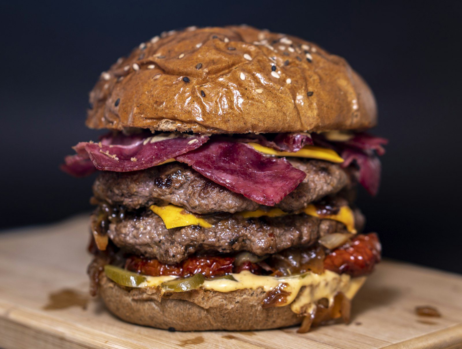 A double smashed burger with melted cheese and bacon