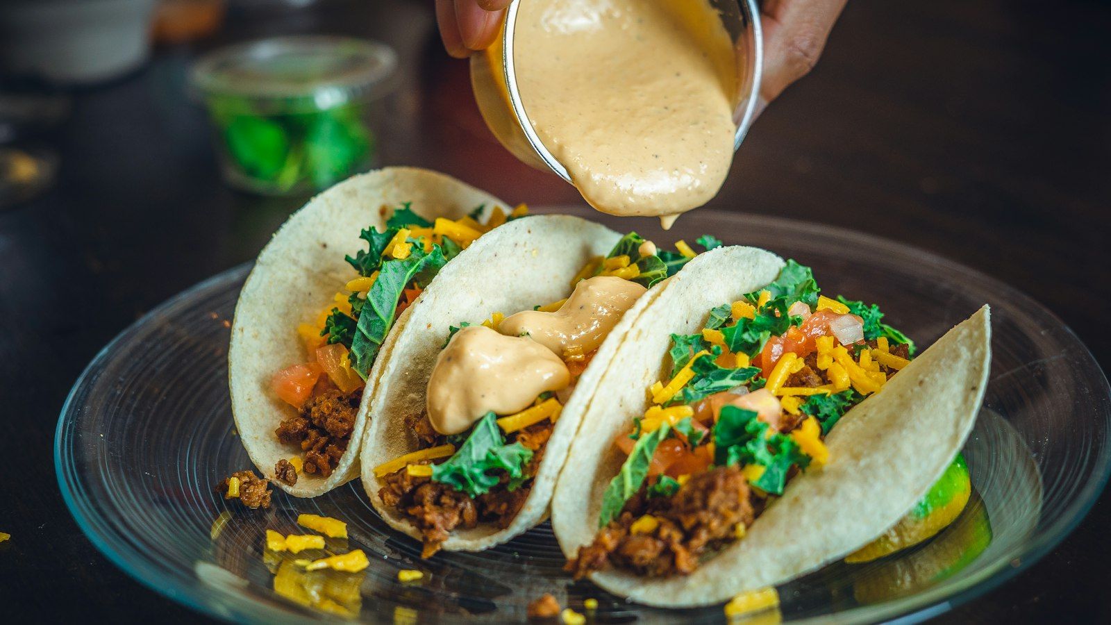 Tacos with sauce being poured