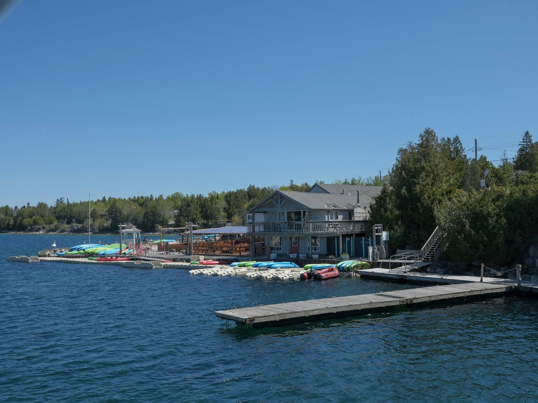 Lodge and colorful boats docked on serene blue water
