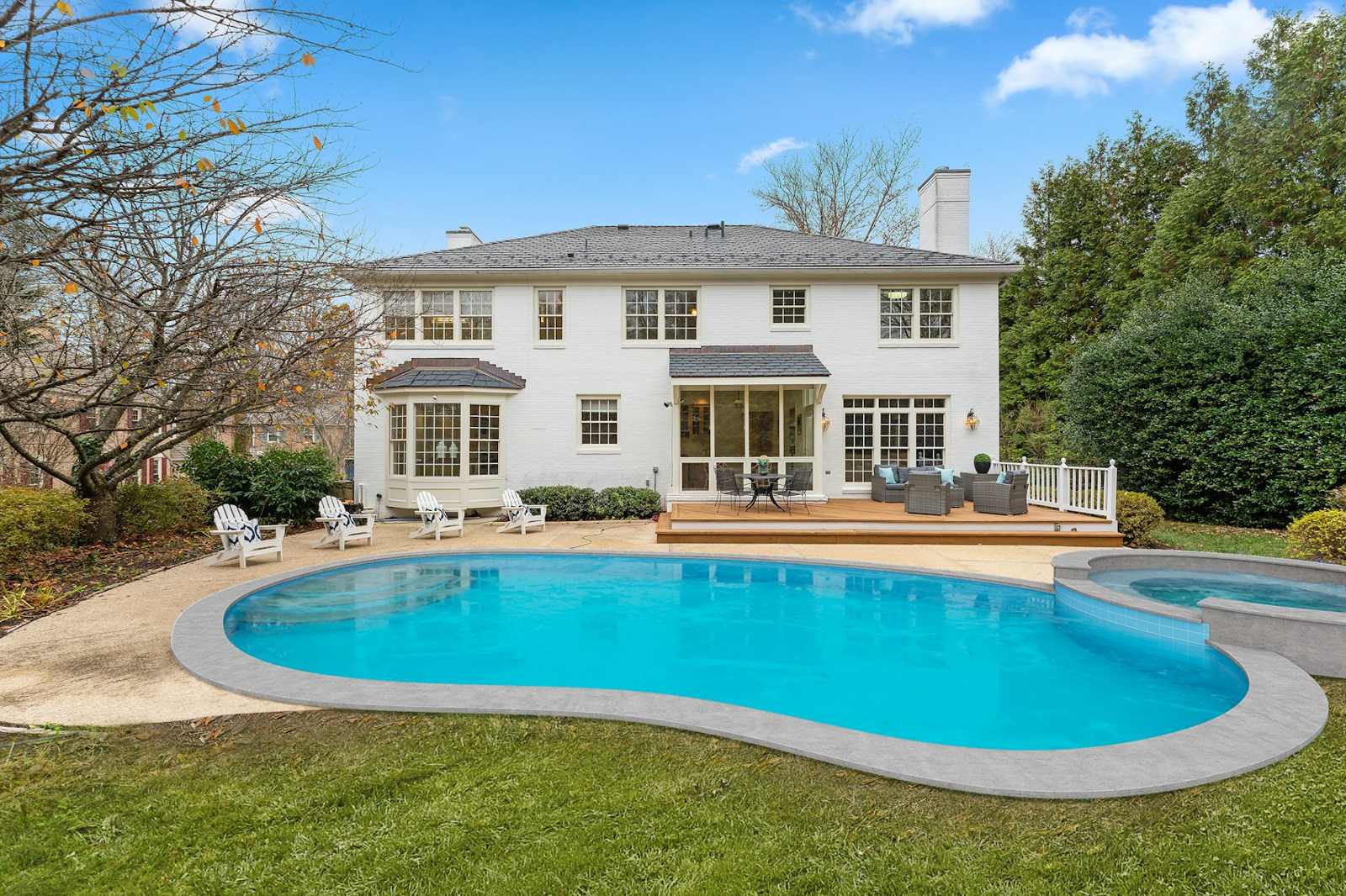 Backyard pool beside a white house