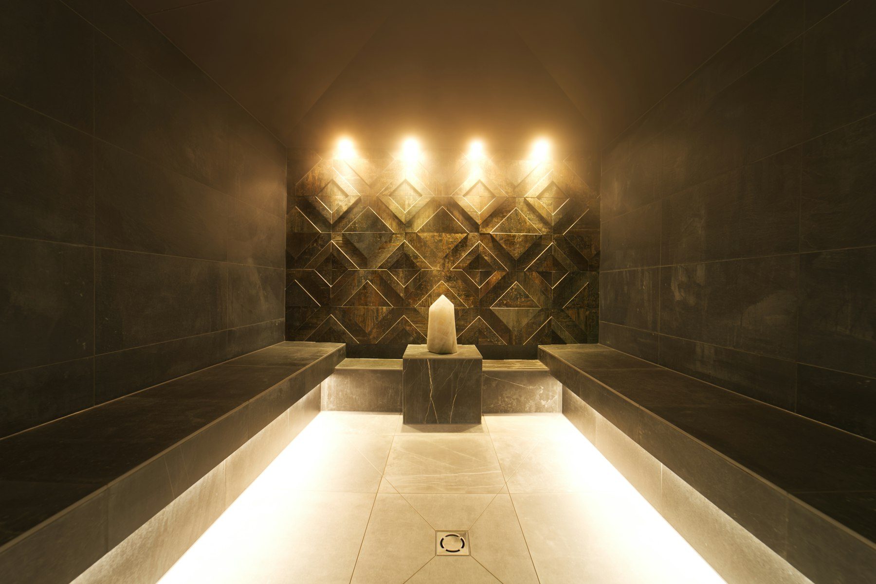 A modern steam room with a candle and ambient lighting