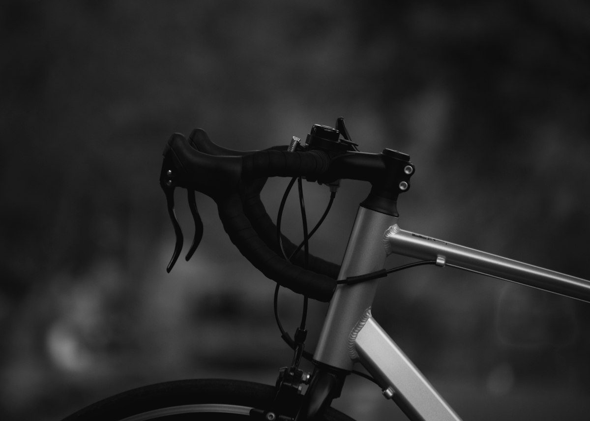 A close up of a bike handlebar with a blurry background