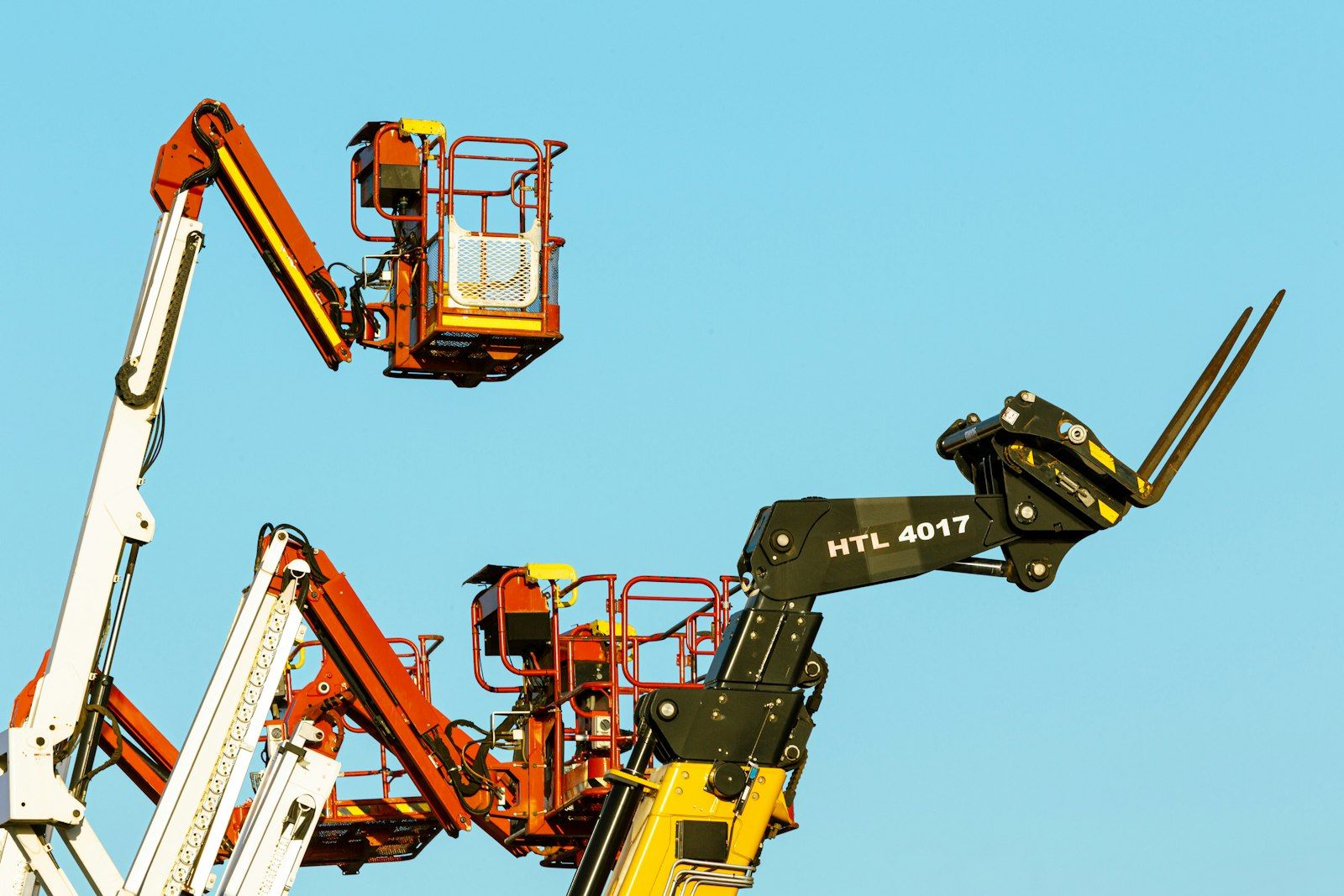 Boom lifts against blue sky