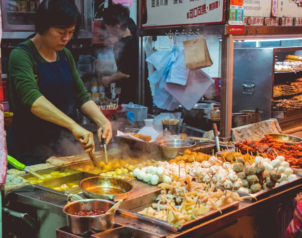 A cook working a hot street-food counter