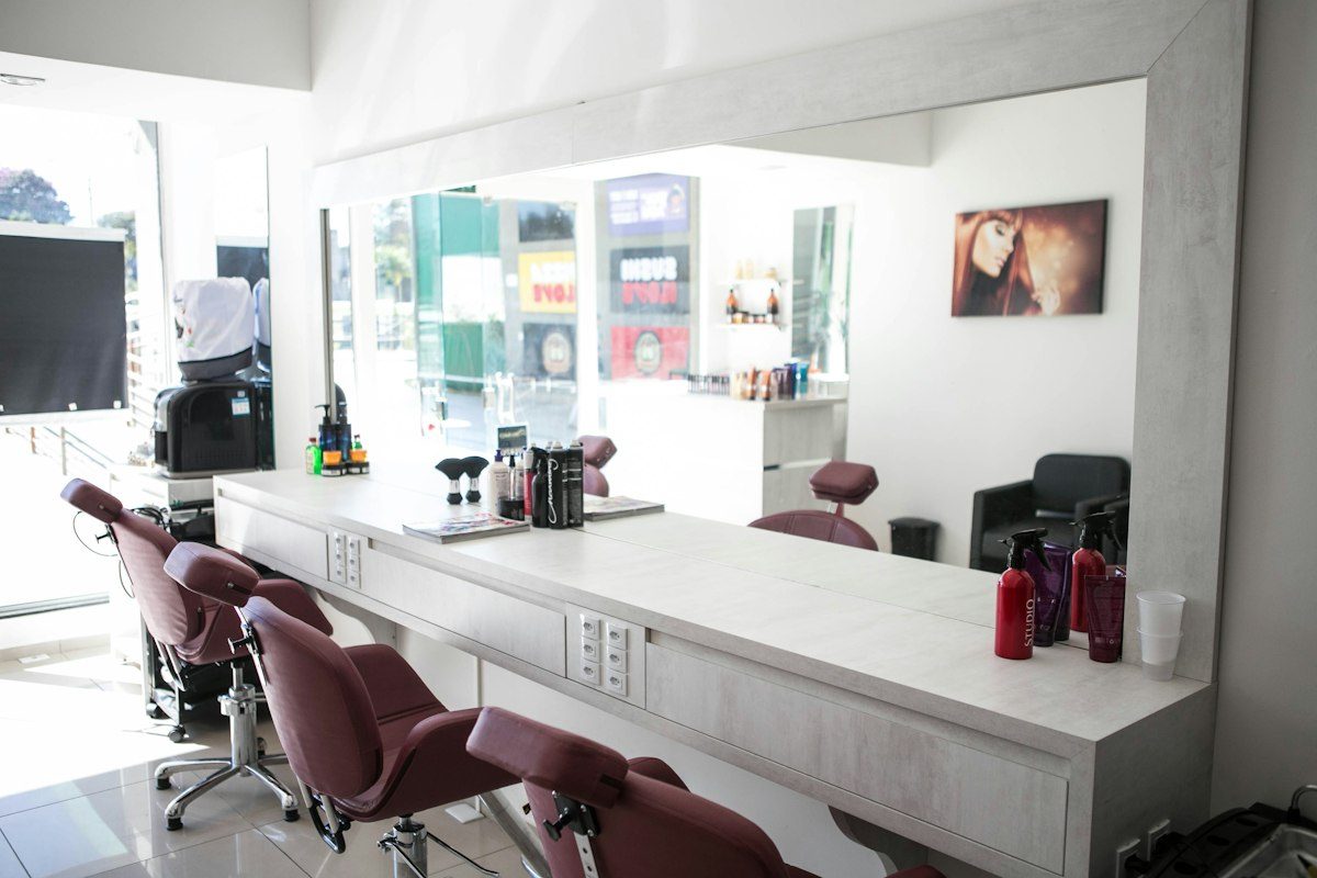 A hair salon with chairs and a mirror