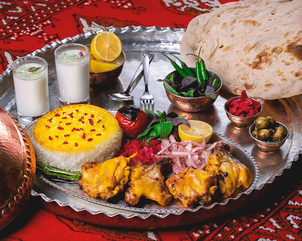 A Persian feast with saffron rice, kebabs and bread on a copper platter