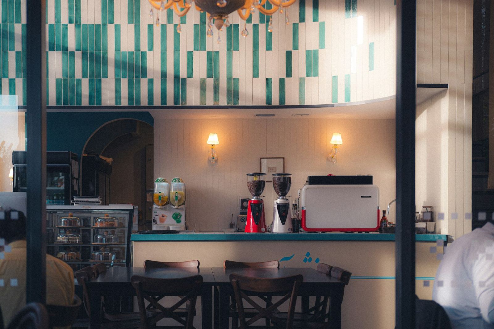 A cafe window with a teal tiled wall and an espresso machine