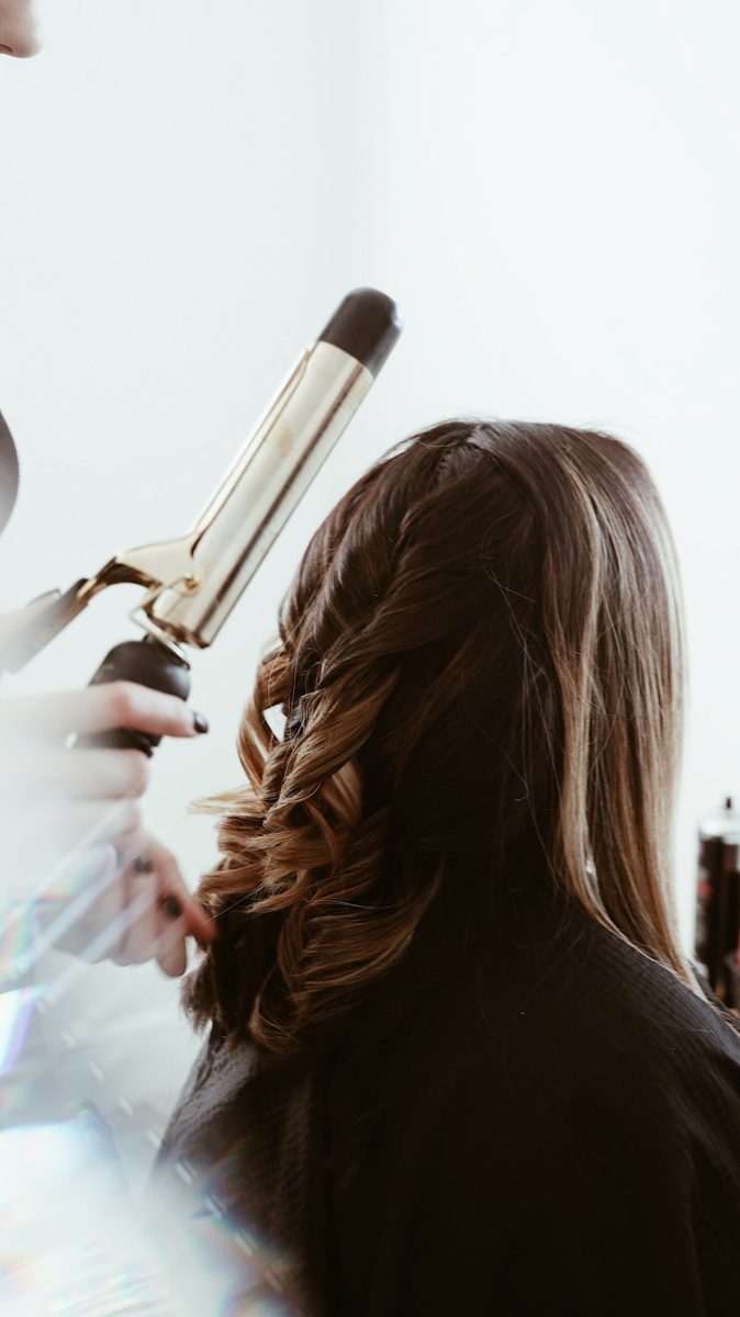 Person holding gray hair curler