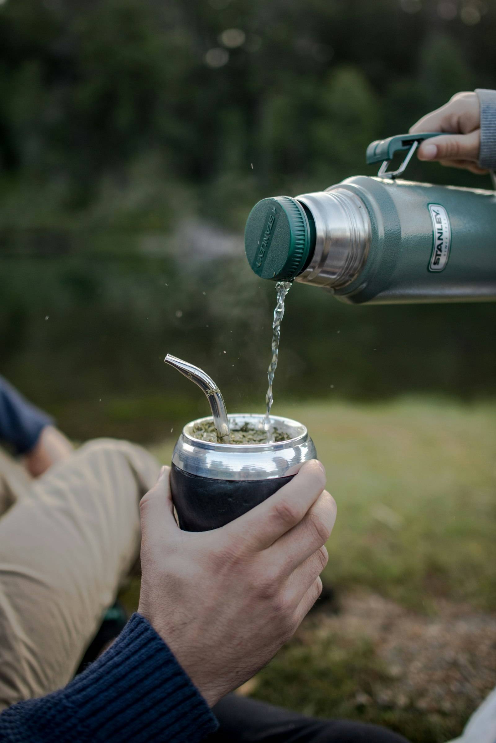 Pouring hot water into a mate cup outdoors